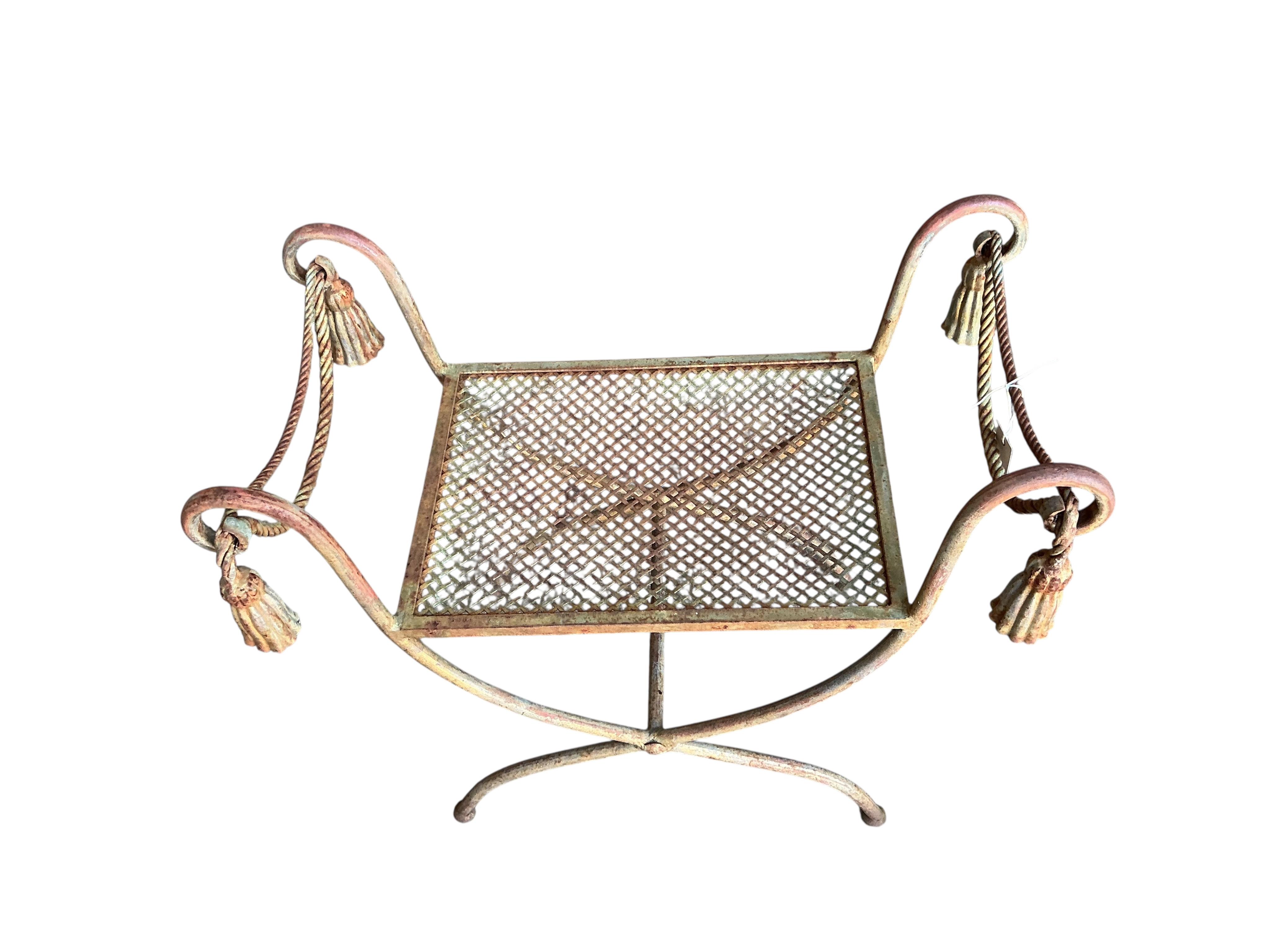 A wrought iron X-framed stool, width 71cm, depth 40cm, height 61cm